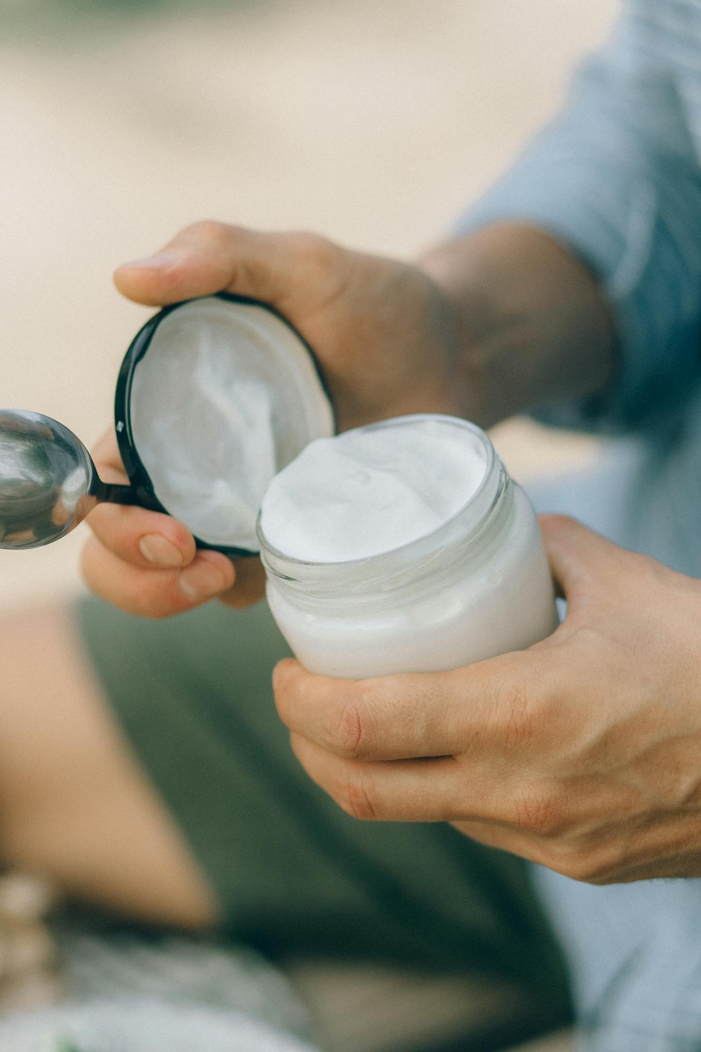 Detailed shot of hands opening a jar of cream, ideal for skincare and natural product concepts.
